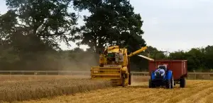 Image of automated combine harvester and tractor on a field on the Hands Free Farm