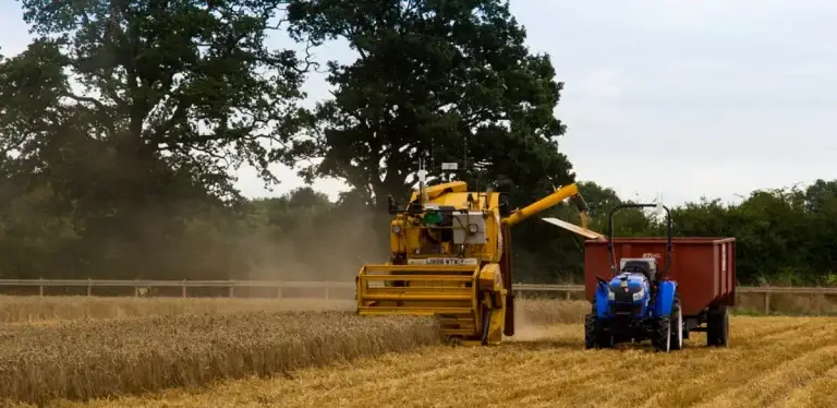 Image of automated combine harvester and tractor on a field on the Hands Free Farm