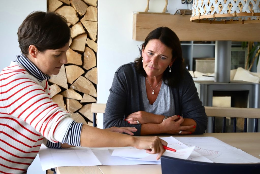 Two people sat at kitchen table looking at paperwork